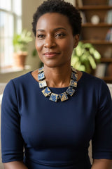 Woman wearing a blue dress with a Square shape necklace handmade from recycled wood, minimalist style in a home setting