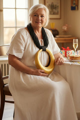 Woman in a white dress wearing Lightweight and sculptural art to wear necklace handmade from sustainable material, made from bamboo.