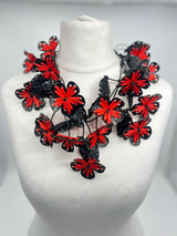 Black and red floral necklace on a mannequin bust against a white background