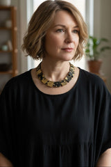 Woman wearing a black top and a Sustaianble jewelry necklace handmade from recycled wood, minimalist style